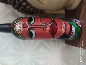 Women traditional face on glass bottle